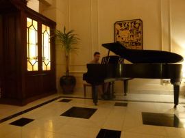 Playing an 18th century piano at the Strand Hotel